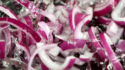 Super Slow Motion Shot of Falling Red Onion Cuts into Oil in Pan at 1000 fps.