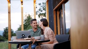 Young couple with laptop outdoors, weekend away in container house in countryside. - Powered by Shutterstock - Get 15% off with code: PIKWIZARD15