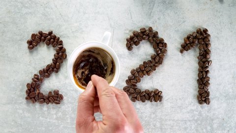 Coffee inscription of year 2021 with splashing liquid, super slow motion at 1000 fps.