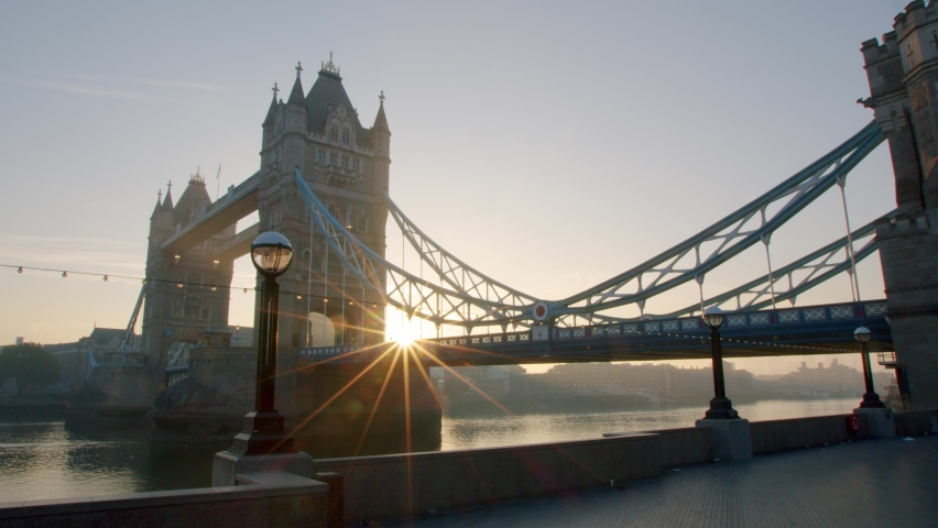 Lockdown in London, slow motion gimbal pan of golden hour sunrise sun flare through the stunning Tower Bridge, during 2020's Coronavirus pandemic. | Shutterstock HD Video #1061297542