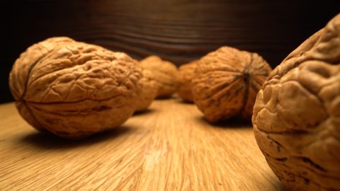 Walnut close up on a wooden table. Vertical sliding camera moving through nut. Laowa probe lens.