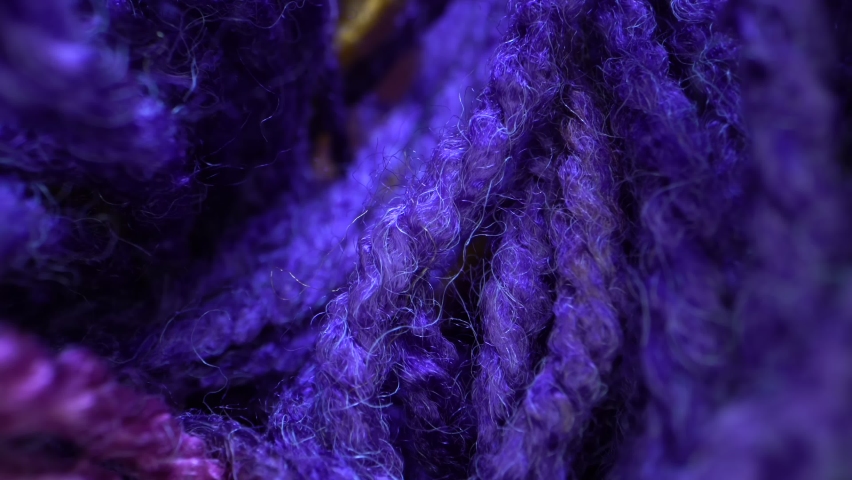 The multi colored wool yarn is close up to show the detailed texture. Vertically sliding camera moving along a bright rainbow yarn. Dolly super macro shot. Royalty-Free Stock Footage #1061300143