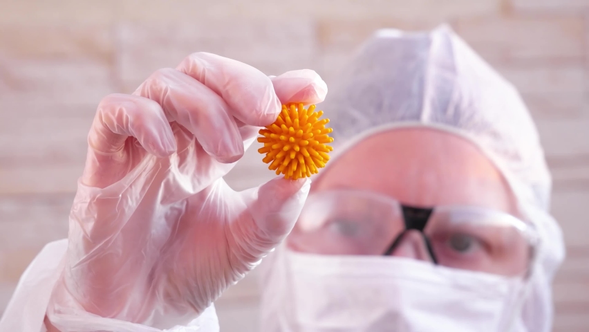 A scientist holding a model of coronavirus