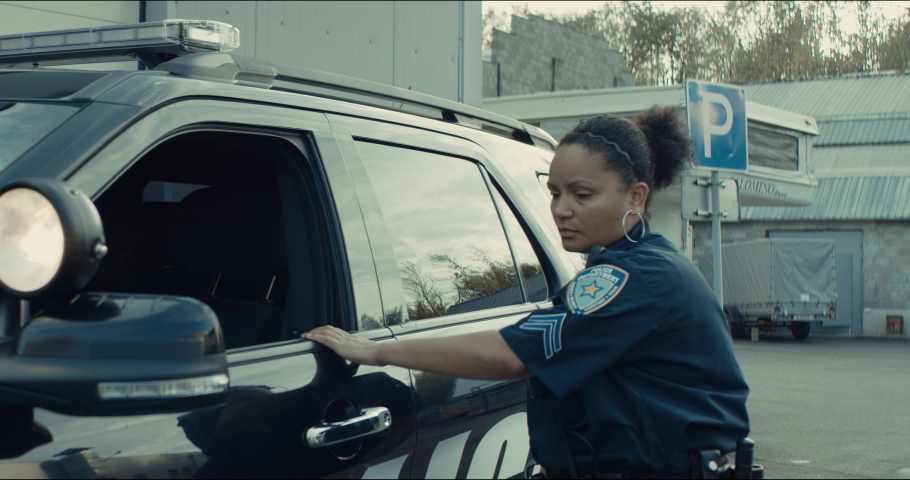 African-American black driver is being pulled off by mixed-race female police officer. Documents check, speeding ticket. Shot on RED cinema camera with 2x Anamorphic lens Royalty-Free Stock Footage #1061301589