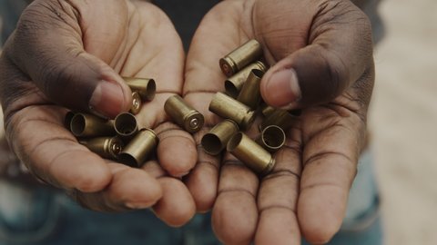Close up, african man holding bulet cases in his hands