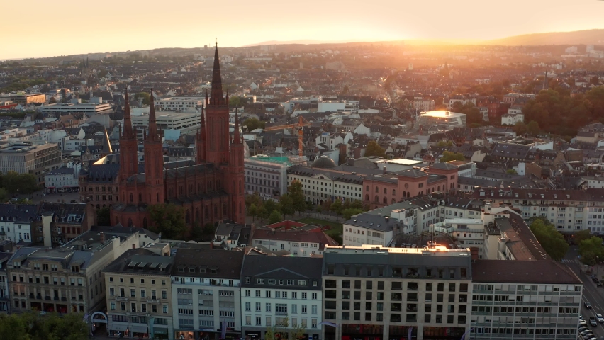 Wrapping around the Marktkirche in Wiesbaden Germany with a drone in the evening right before sunset showing the old town and the city center Royalty-Free Stock Footage #1061302924