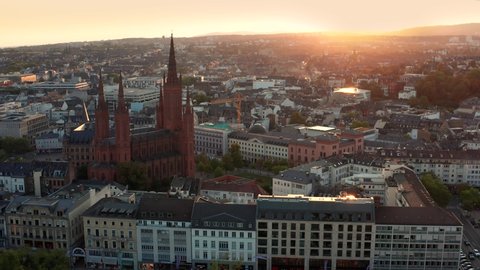 Wrapping around the Marktkirche in Wiesbaden Germany with a drone in the evening right before sunset showing the old town and the city center