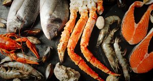 Different types of seafood on the table. On a black background. 