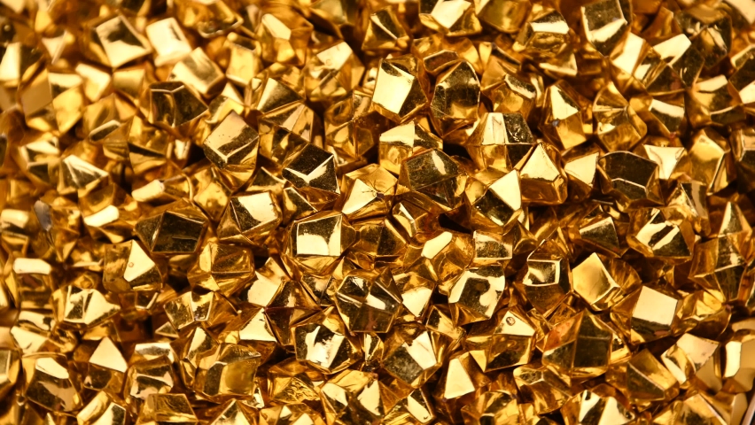 Abstract background of colorful bright golden nuggets spin and flicker, 4K