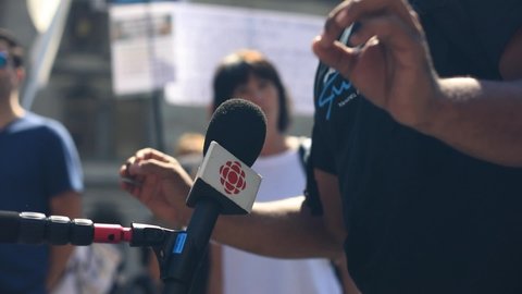 Quebec, Canada, August 8,2020: Selective focus of male hands making gestures while talking over CBC Radio mic during rally against mask