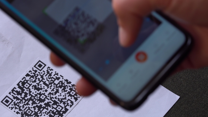Scanning a QR code And Contactless Payments during Covid-19 Pandemic. A man scans the QR code displayed by the merchant with their phone to pay for service. COVID-19 vaccination certificate Royalty-Free Stock Footage #1061324575