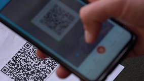 Scanning a QR code And Contactless Payments during Covid-19 Pandemic. A man scans the QR code displayed by the merchant with their phone to pay for service. COVID-19 vaccination certificate - Powered by Shutterstock - Get 15% off with code: PIKWIZARD15