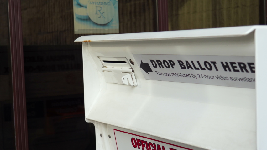 Young Man Drops Mail-in Ballot Letter in Slot at Official Voting Box with Drop Ballot Here Sign Royalty-Free Stock Footage #1061330602