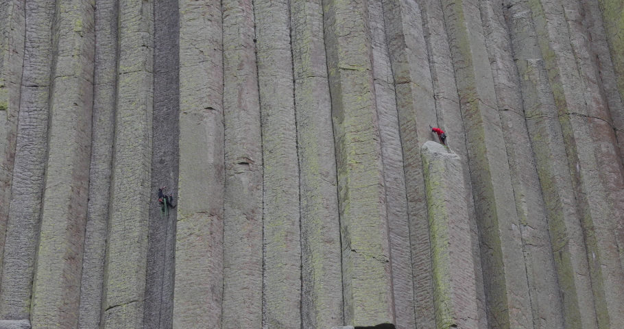 Rock climbers high on Devils Tower Wyoming 4K. Rock tower in Black Hills of South Dakota and Wyoming. National Monument. Recreation, tourism, vacation, and rock climbing destination.