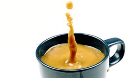 Sugar cube falls into coffee mug, cup with white coffee on white background in slow motion, close-up. Hot morning energy drinks, coffee break, white sweet coffee, breakfast, ingredients concept - Powered by Shutterstock - Get 15% off with code: PIKWIZARD15