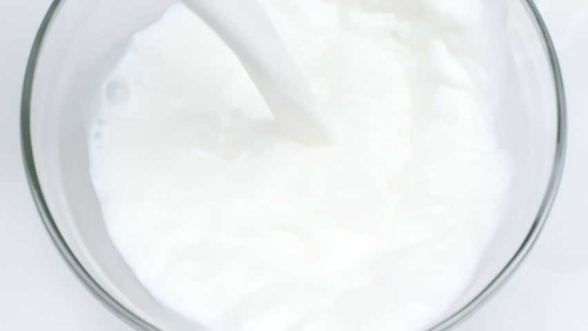 Close-up delicious natural milk is poured into glass bowl in slow motion, organic food and fresh drink concept, white background. White liquid, healthy eating, soya rice coconut skim milk, nutrition | Shutterstock HD Video #1061349388
