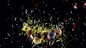 mix of handmade luxurious candies of white and dark chocolate in burst of golden tinsel and red stars slow motion isolated on black backdrop. Christmas sweets concept. chocolate advertisement intro - Powered by Shutterstock - Get 15% off with code: PIKWIZARD15