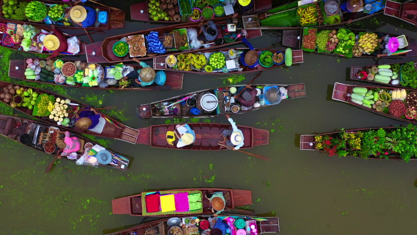Aerial view famous floating market in Thailand, Damnoen Saduak floating market, Farmer go to sell organic products, fruits, vegetables and Thai cuisine, Tourists visiting by boat, Ratchaburi, Thailand | Shutterstock HD Video #1061362279