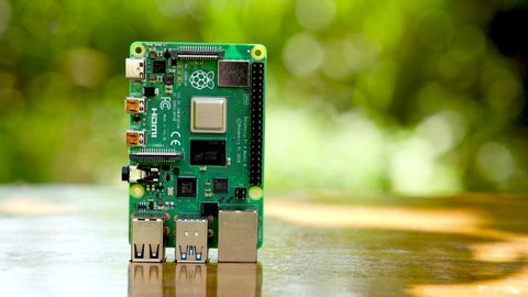 Raspberry Pi 4 on a Wooden Table with a live moving Blur Background, this is a 4k footage of a raspberry pi computer.