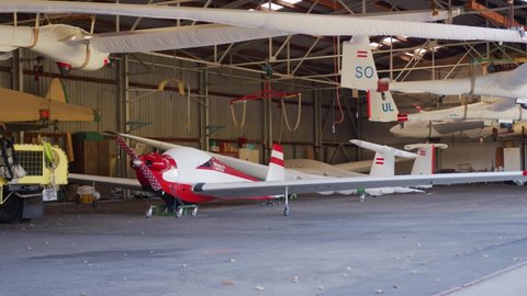 Airplane hangar. Glider on hangar roof. Parking airplane. Sailplanes hanging from the roof on an airport. Small airport. Glider plane.