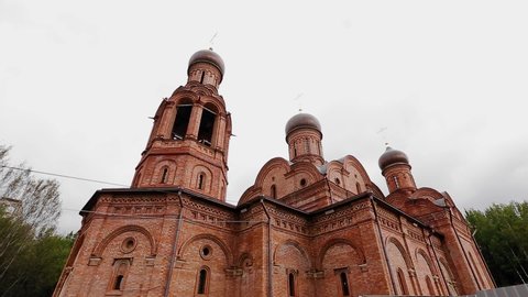The church is of red brick. The camera shoots outside in motion. taken with a wide-angle lens
