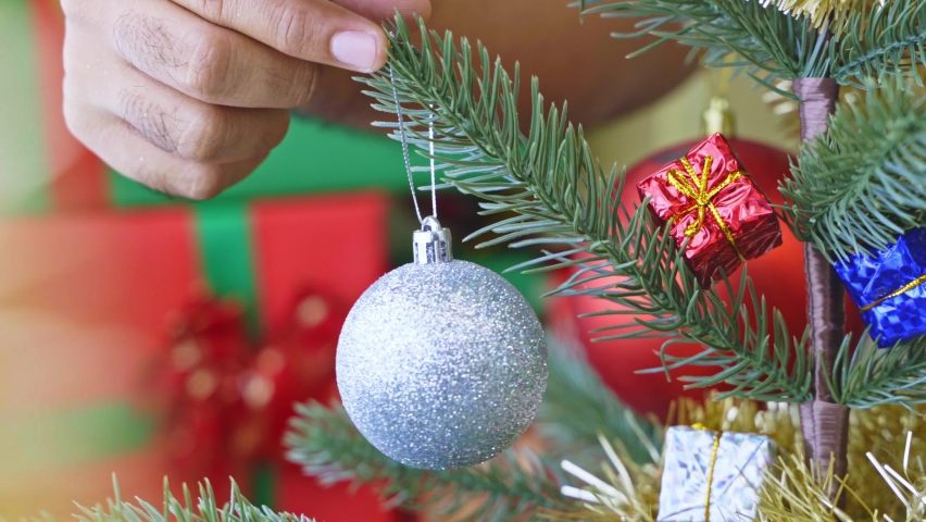 Close up hand man decoration christmas tree with silver ball in christmas festival. Merry Christmas and Happy New Year background concetp. 4k Resolution.