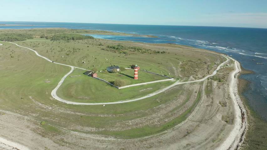Desolate lighthouse, aerial footage flying over a bautiful coastal area