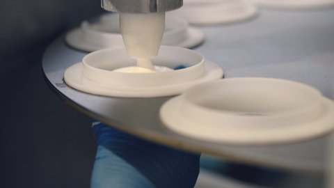 Waffle Cups are Filled by White Vanilla, Caramel Ice Cream, Modern Automated Industrial Line in the Plant of Ice Cream Production, Tasty Sweet Food, Dessert, Hands, Close Up