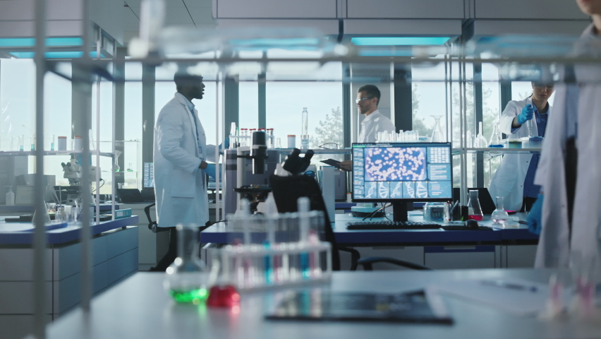 Medical Science and Biotechnology Laboratory with Diverse Team of Research Scientists Working. Microbiologist and Biochemist Talking, Using Digital Tablet Computer and Micropipette. Dolly Slow Motion | Shutterstock HD Video #1061389468