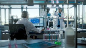 Medical Science Laboratory with Diverse Team of Biochemistry Research Scientists Talking, Working with Microscopes, Computers, Micropipettes. Developing Drug High-Tech Equipment. Slow Motion - Powered by Shutterstock - Get 15% off with code: PIKWIZARD15