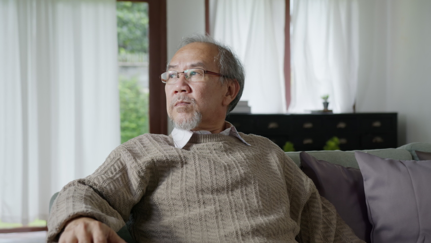 Close up candid of asian family multi generation sitting on sofa at living room. Grandfather feeling worry, lonely and depress is supported and take care by family during quarantine covid pandemic. | Shutterstock HD Video #1061392072