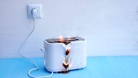 Toaster on fire. Household electrical appliance fire hazard. Overload. Short circuit. Carelessness. Safety in home. Danger home inflammation Insurance concept