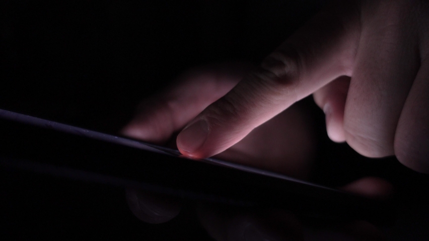 Young male checking on his phone during the night. Bright touchscreen in the dark. Browsing social networks. Procrastination before sleep. Selective focus of a man using his phone. | Shutterstock HD Video #1061398021