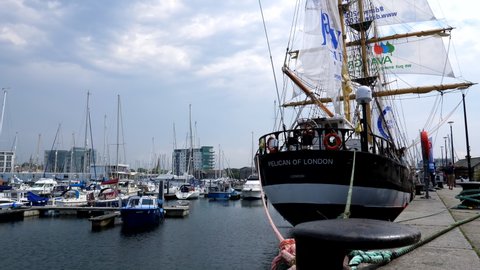 PLYMOUTH, ENGLAND, UNITED KINGDOM - CIRCA AUGUST, 2020: Low angle view of tall sailing ship Pelican of London moored by the paved area in Plymouth city marina.