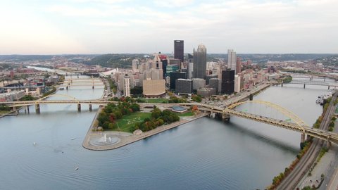 Wide aerial establishing shot of Pittsburgh Pennsylvania. Point State Park and boats on Allegheny and Monongahela Rivers. Drone above Mount Washington. City of Bridges.