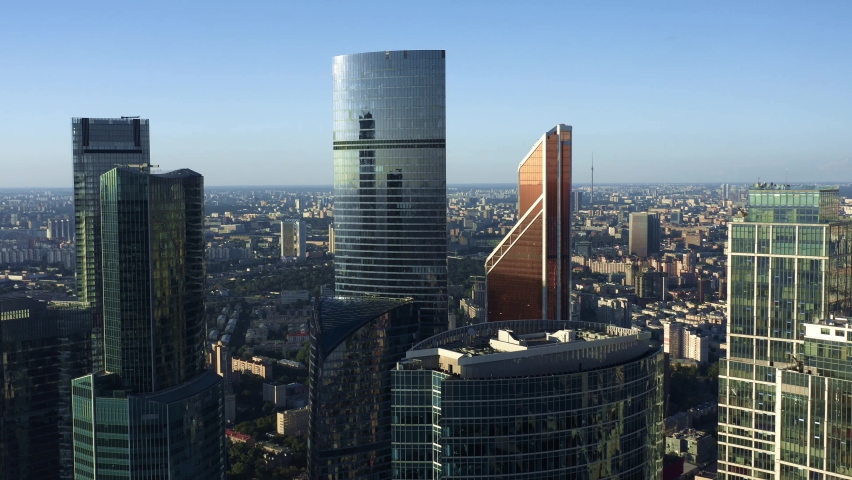 Moscow city glass skyscrapers drone zoom out shot. Top view shot of Moscow International Business Center during a sunny day, daylight blue sky, camera moving back Royalty-Free Stock Footage #1061410816