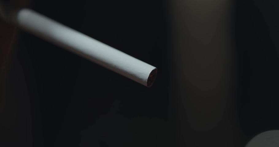Close up of person lighting cigarette from lighter and smoking, dark background | Shutterstock HD Video #1061412721