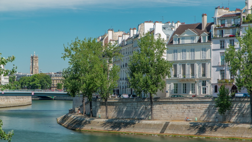 Saint-Louis bridge timelapse with houses on Orleans waterfront. Two islands on the River Seine in Paris, France, called Ile de la cite and Ile saint Louis. Paris, France.