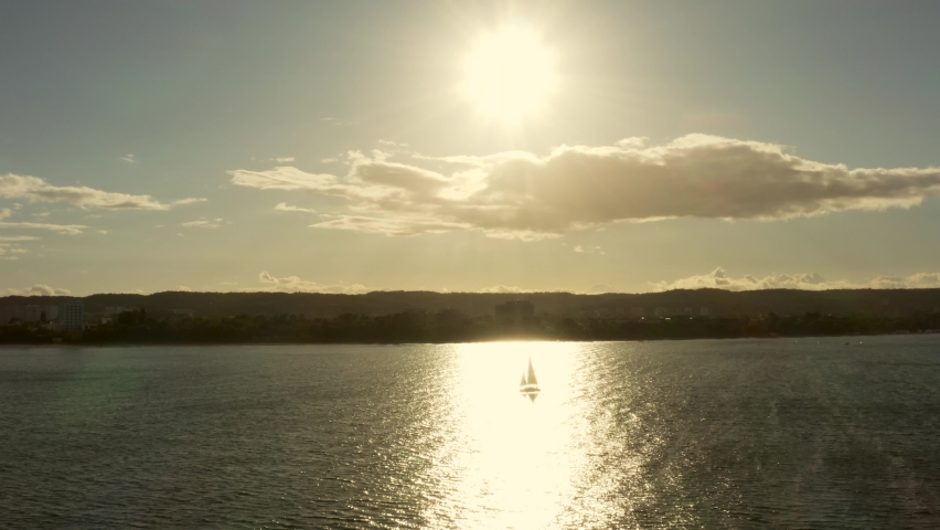 Sailing Yacht at Sunset. The Sun's Rays are Reflected on the Water Surface With the Silhouette of a Sailboat. eautiful Sunset With a Sailboat on a Summer Colorful Evening.