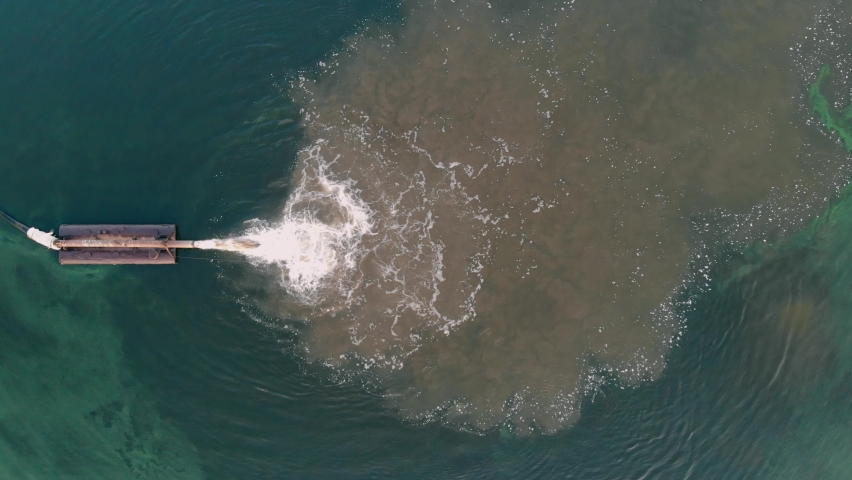 Dirty water flows into the river through a pipe. Pollution of the environment and water bodies. Ecological catastrophy. Shooting from a copter Royalty-Free Stock Footage #1061429977