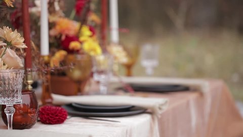 Thanksgiving dinner. Seasonal table setting with autumn leaves, candles and flowers. Beautiful table full of fruit and drink in inside on the table rustic dark background.