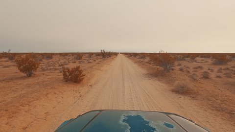 Driving along an off-road trail in the barren and endless Mojave Desert landscape