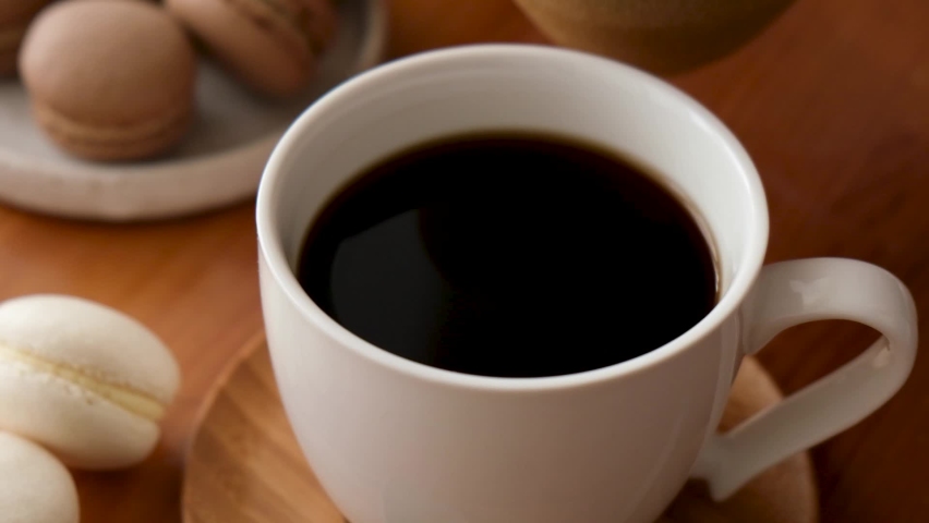 Adding coffee creamer into black coffee. Slow motion cream pouring in a cup of black coffee | Shutterstock HD Video #1061442259