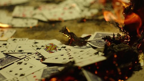 Falling playing cards into bonfire .
Cards falling, flying on burning floor . This clip is perfect for projects about casino or fall of a business or empire. Shot on ARRI cinema camera in Slow Motion