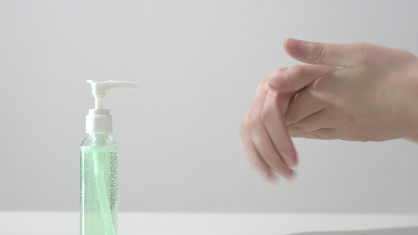A woman uses hand sanitizer gel for clean hands to prevent the spread of coronavirus. Using rubbing alcohol instead of washing hands. Measures to prevent spread of covid-19 virus. Disinfecting hands. | Shutterstock HD Video #1061448610