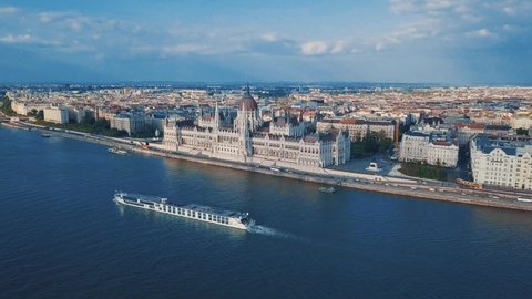 Aerial drone video of Hungarian Parliament building situated in touristic center of Budapest.Tourist ships cruising in river Danube in spring,filmed in 4K video clip from above with flying videocamera