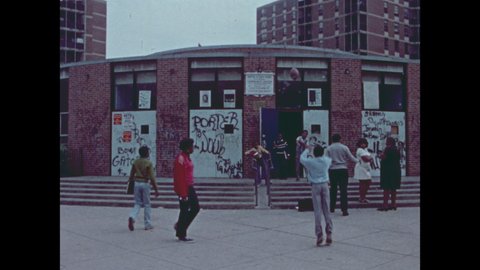 1970s: Children play ball outside graffiti covered building. People enter civic association building.