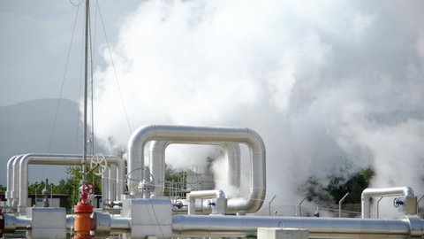Geothermal station with steam and pipes in the rainforest. Billowing steam from smoke stack filling sky, super slow motion close up. Buharkent, Turkey