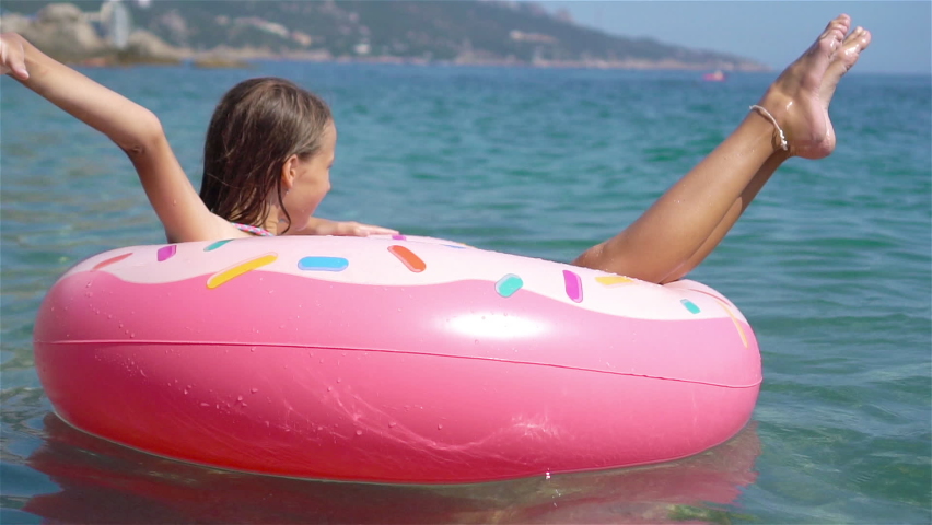 Adorable girl relaxing on inflatable air mattress in the sea