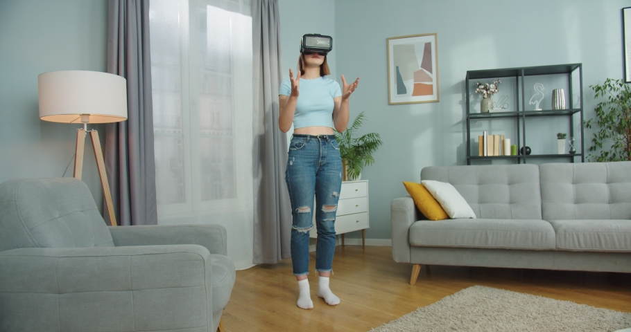 Good-looking Caucasian woman wearing virtual reality headset. Pretty young female playing, using modern vr glasses indoors. Googles, 3D. Technology, gaming, entertainment concept. | Shutterstock HD Video #1061467444